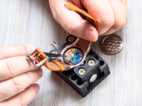 watchmaker changes battery in quartz wristwatch