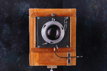 Vintage wooden camera with shutter on a cement background. The old studio camera for using plates.