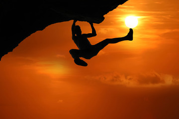 Free climbing on the mountain at red sky sunset background