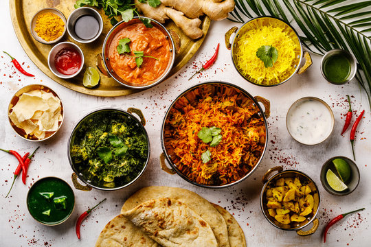 Indian food Curry butter chicken, Palak Paneer, Chiken Tikka, Biryani, Papad, Dal, Rice with Saffron and Naan bread on white background