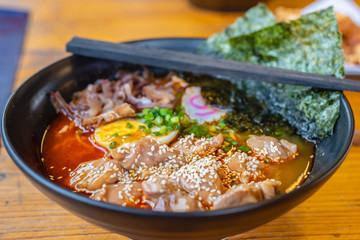 Spicy ramen Japanese noodle soup in a black color ramen bowl.