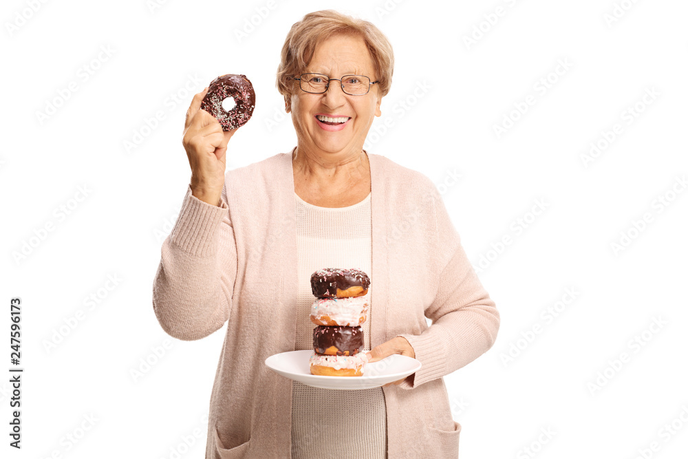 Poster cheerful elderly woman holding a plate of doughnuts in one hand and one doughnut in the other hand