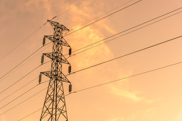 High voltage electricity post in colorful sunset sky background.
