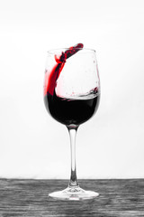 Red wine in the glass splashes in motion on a white background. Design card
