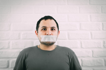 Angry man mouth covered by masking tape