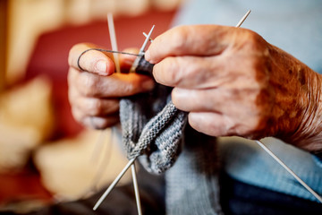 Hände einer strickenden Seniorin