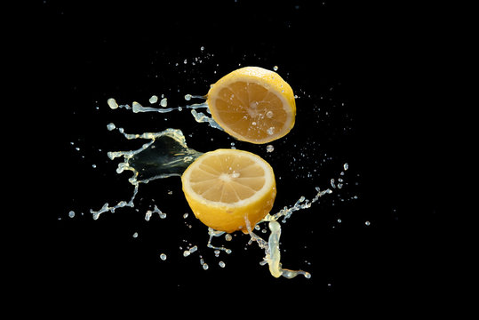 Lemom slice with juice splash isolated on black background