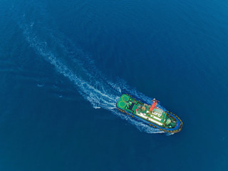 Tug boat for drag container ship at sea port for logistic, import export, shipping or transportation.