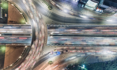 Aerial top view highway road intersection roundabout or circle at night for transportation, distribution or traffic background.
