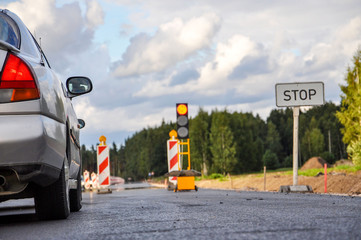 A row of cars at the road repair semaphore, selective focus, blurred background - image