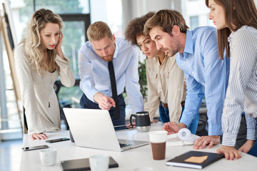 Fototapeta premium Small group of business people standing at office and solving problem at meeting. Multi cultural group.