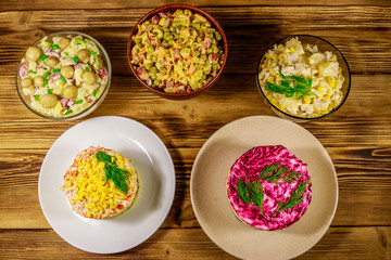 Set of festive mayonnaise salads on wooden table. Top view