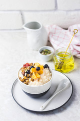 Healthy rice pudding with berries, granola and honey. Selective focus, space for text.