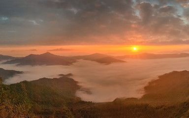 sunrise at Doi Pha Tang, beautiful mountain view morning panorama 180 degree of top hill around with sea of mist with yellow sun light and cloudy sky background, Chiang Rai, Thailand.