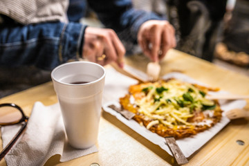 hands cutting pizza