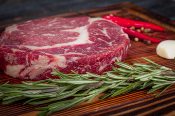  beautiful and juicy raw steak on the table with ingredients ready to roast