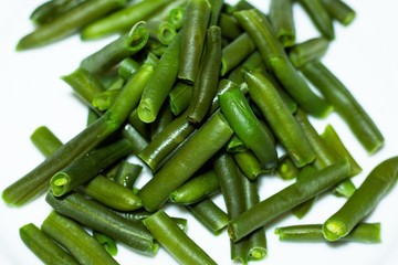 Green beans lie on the surface of white. Fresh and natural product of healthy nutrition.