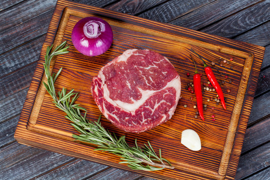  beautiful and juicy raw steak on the table with ingredients ready to roast