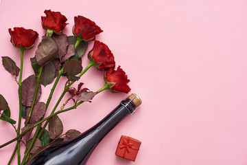 Obraz na płótnie Canvas Celebrating special date. Surprise her with red roses, champagne and small red gift box