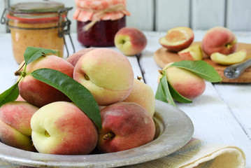 Fresh peaches in metal bowl. Making of jam or confiture from organic fruits and berries on a light background. Copy space.