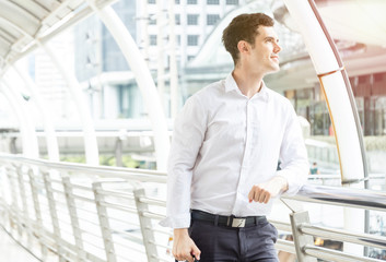 Fototapeta premium Young businessman standing and look up to the sky and thinking about business plan at outdoor in the big city. Business concept with copy space.
