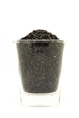 Black sesame in glass isolated on white background; provides protein, dietary fiber, vitamins, and dietary minerals in rich. Super food of life.