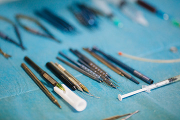 Surgical instruments lie on a sterile table in the operating room.