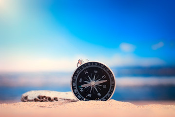 Time to Travel. Idea for tourism with compass on the sand with corals on the background of the sea.