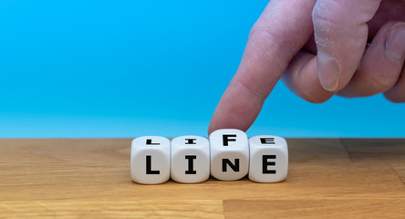 Hand turns a dice and changes the word "LIFE" to "LINE"
