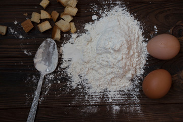 flour, chicken eggs on a wooden table, top view, cooking a delicious dish