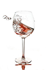 Red splashes of clean water in the wine glass. A spray of water. Drinking water.
