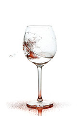 Red splashes of clean water in the wine glass. A spray of water. Drinking water.