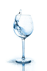 Blue splashes of clean water in the wine glass. A spray of water. Drinking water.