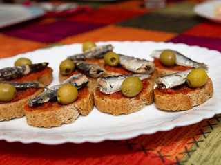 appetizer with sardines and olives on bread