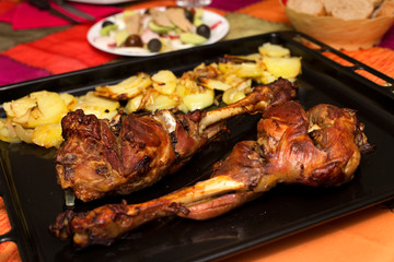 roast leg of lamb with potatoes on a baking tray