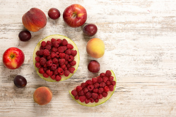 Fruit mix. Peach, watermelon, apple, raspberry, plum, lie on a white wooden background. Flat Lay, Copyspace