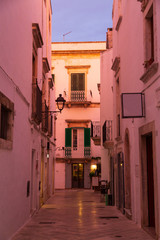 Obraz premium Narrow white street in Locorotondo oldtown during sunset, province Bari, Italy