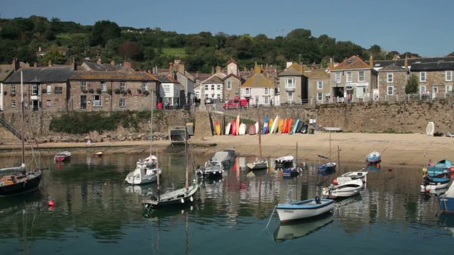 Yachts and boats moored in Mousehole harbour in front of the quay wall, Cornwall
