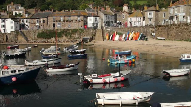 Yachts and boats moored in Mousehole harbour in front of the quay wall, Cornwall