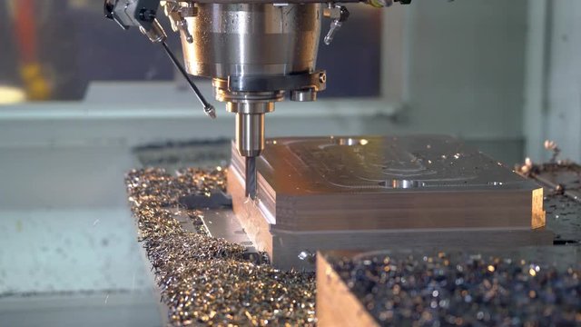 CNC milling machine cutting steel in a machine shop.