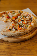 Beautiful fresh hot pizza on a wooden run.