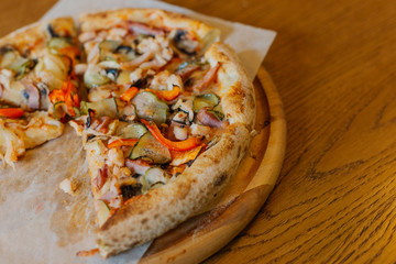 Beautiful fresh hot pizza on a wooden run.