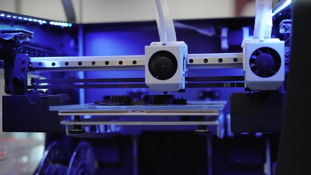 3d Printer close up, printer head moves towards camera into focus