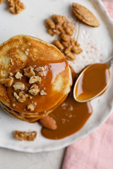 Close up stack of pancakes with caramel and nuts with spoon