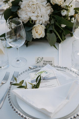 Classic white set of wedding dinner table. White bouquets as a centerpiece
