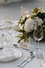 Classic white set of wedding dinner table. White bouquets as a centerpiece