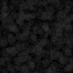 Abstract seamless pattern of randomly distributed translucent circles in black and gray colors