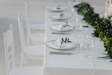Classic white set of wedding dinner table. White bouquets as a centerpiece