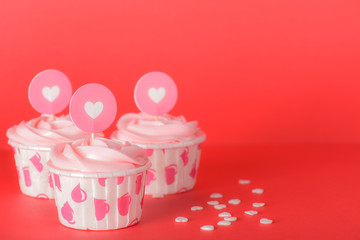 Tasty pink pastel butter cream cupcakes on red background, delicious butter cream cupcakes, Valentines cupcakes, hearts for Valentines, Valentines day card concept.