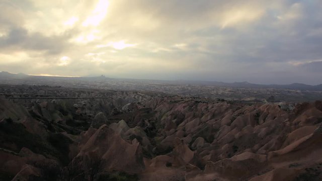 timelapse of clouds moving forwards, by steady footage, over xanthic chimney rocks, after sunset in an overcast weather, in Cappadocia, Nevsehir, Turkey